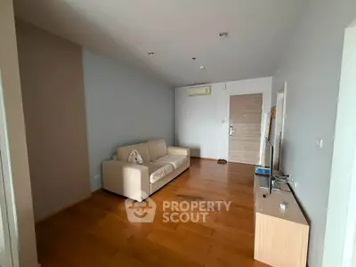 Spacious living room with wooden flooring and modern furnishings in a stylish apartment.