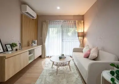 Modern living room with cozy sofa, stylish decor, and natural light through large window.