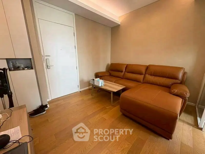 Modern living room with brown leather sofa and wooden flooring