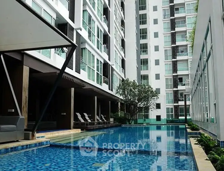 Modern apartment complex with luxurious pool and sleek architecture.