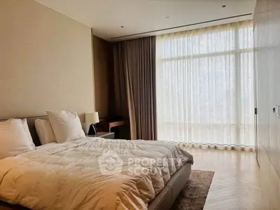 Luxurious bedroom with elegant decor and large window with sheer curtains