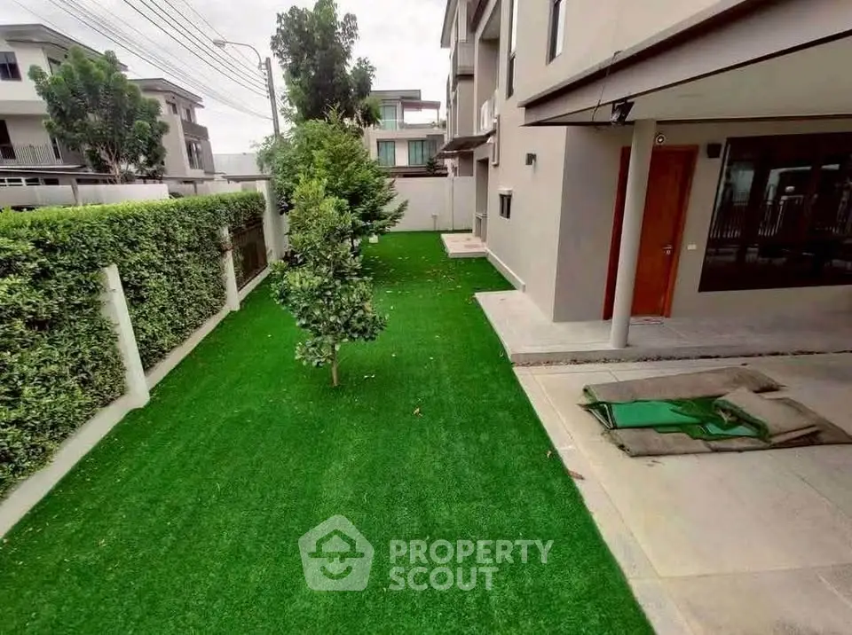 Spacious garden area with lush green lawn and modern building exterior