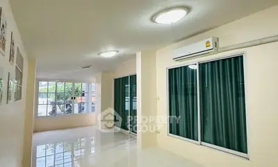 Spacious living room with large windows and air conditioning, perfect for modern living.