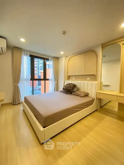 Modern bedroom with elegant design and large window offering city view