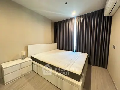 Modern bedroom with sleek design, featuring a comfortable bed and stylish curtains, perfect for relaxation.