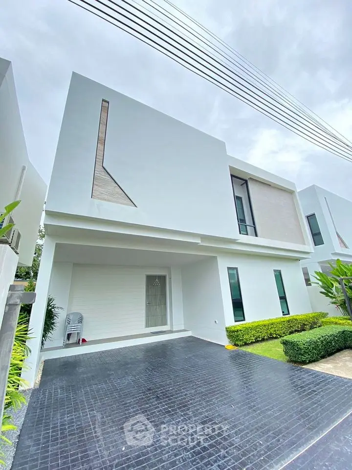 Modern minimalist white house exterior with sleek design and lush green landscaping