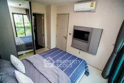 Modern bedroom with air conditioning and balcony view in urban apartment.