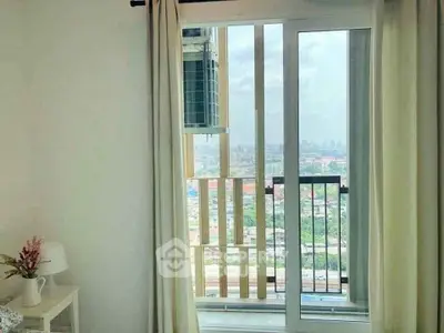 Bright apartment with sliding glass doors opening to a balcony with city view.