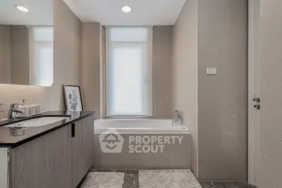 Modern bathroom with sleek design and bathtub in elegant neutral tones.