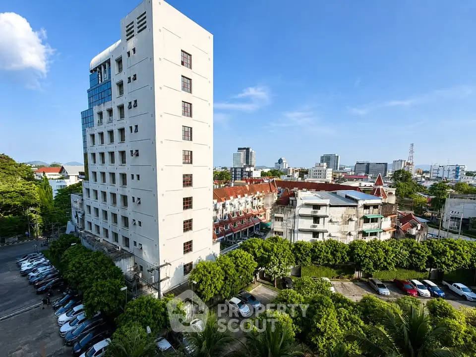 Stunning cityscape view with modern apartment building and lush greenery, perfect for urban living.