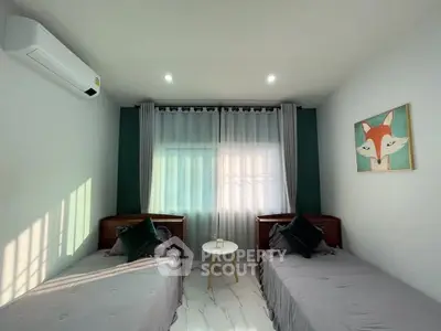 Cozy bedroom with twin beds, modern decor, and natural light