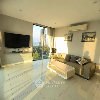 Modern living room with large windows and city view, featuring sleek furniture and wall-mounted TV.