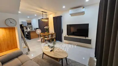 Modern living room with open kitchen, stylish decor, and cozy ambiance