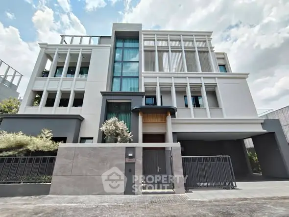 Modern luxury building exterior with sleek design and large windows under a bright sky.