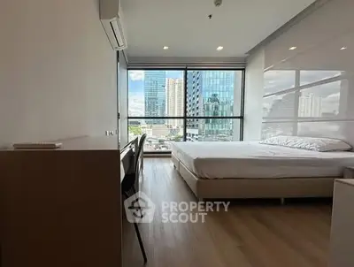 Modern bedroom with city view, large windows, and sleek furnishings in urban apartment.