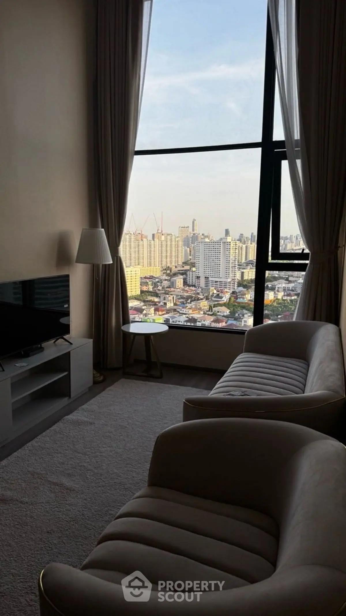 Luxurious living room with stunning city view and elegant furnishings.