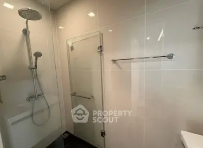 Modern bathroom with sleek shower and glass door in contemporary home.