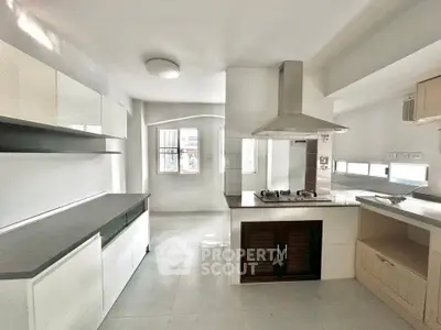 Modern kitchen with sleek design and gas stove, featuring ample natural light and open layout.