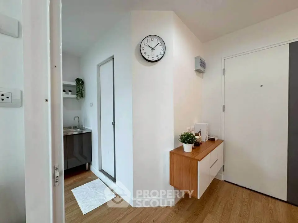 Modern apartment entrance with stylish decor and wall clock