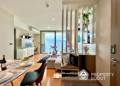 Luxurious open-plan living room with ocean view, modern decor, and elegant dining area.