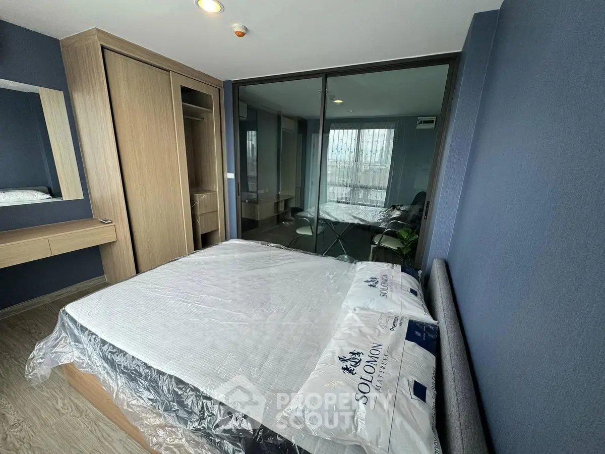 Modern bedroom with sleek design and large mirrored wardrobe in a stylish apartment.