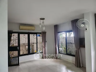 Spacious living room with large windows and modern lighting in a serene home setting.