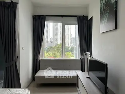 Modern living room with city view, featuring a sleek sofa and flat-screen TV, perfect for urban living.