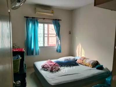 Cozy bedroom with natural light and simple furnishings, perfect for a peaceful retreat.