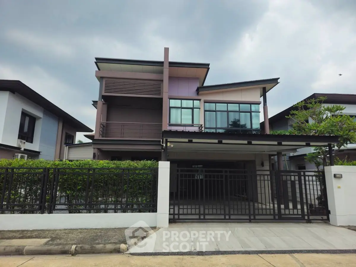 Modern two-story house with sleek design and spacious driveway in suburban neighborhood.
