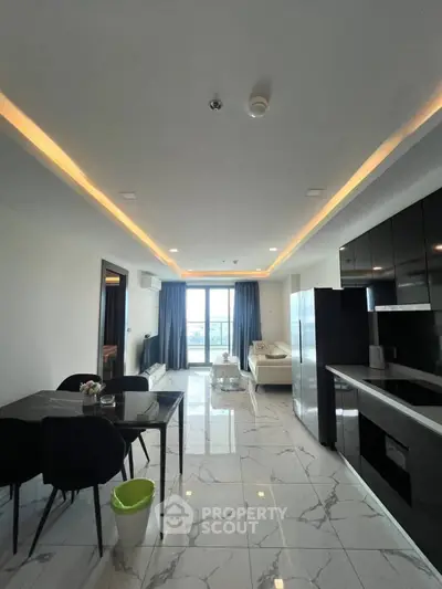 Modern open-plan living room with sleek kitchen and stunning city view.