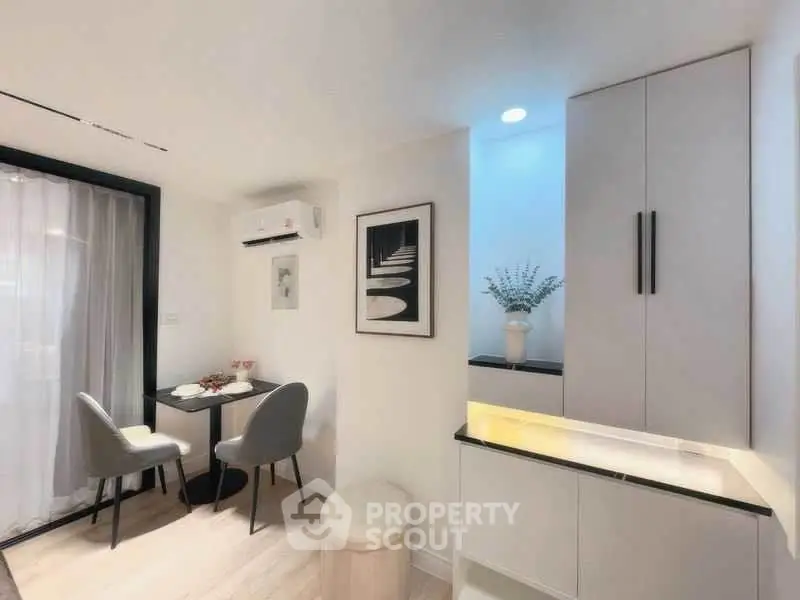 Modern dining area with sleek furniture and stylish decor in a cozy apartment.