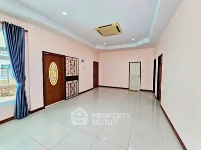 Spacious empty living room with tiled floor and elegant ceiling design.