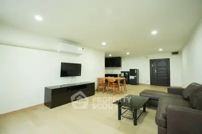Spacious modern living room with sleek furniture and open kitchen layout