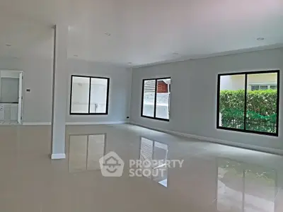 Spacious modern living room with large windows and glossy tiled floors