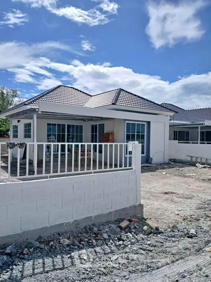 Charming single-story house with modern design and spacious yard under a clear blue sky.