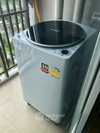 Modern washing machine on a balcony with city view, perfect for urban living convenience.