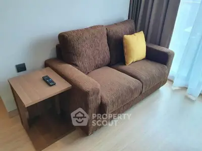 Cozy living room with brown sofa and yellow cushion, perfect for relaxation.