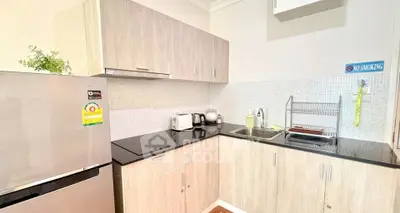 Modern kitchen with sleek cabinets and stainless steel appliances in a cozy apartment.