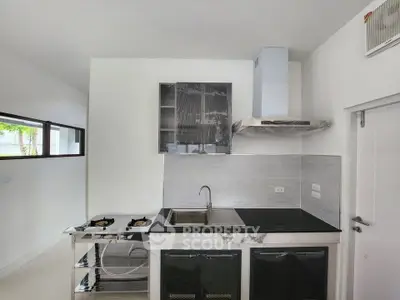 Modern kitchen with sleek design, featuring gas stove and stainless steel sink, perfect for culinary enthusiasts.