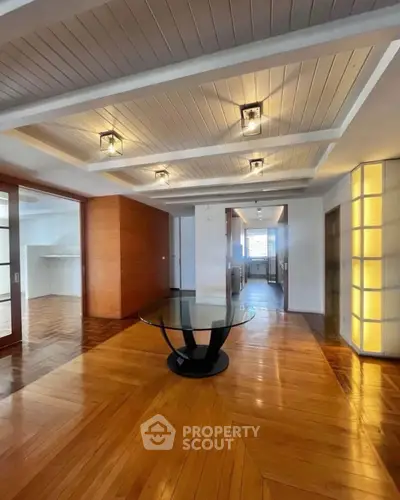 Spacious modern living room with elegant wooden flooring and stylish ceiling lights.