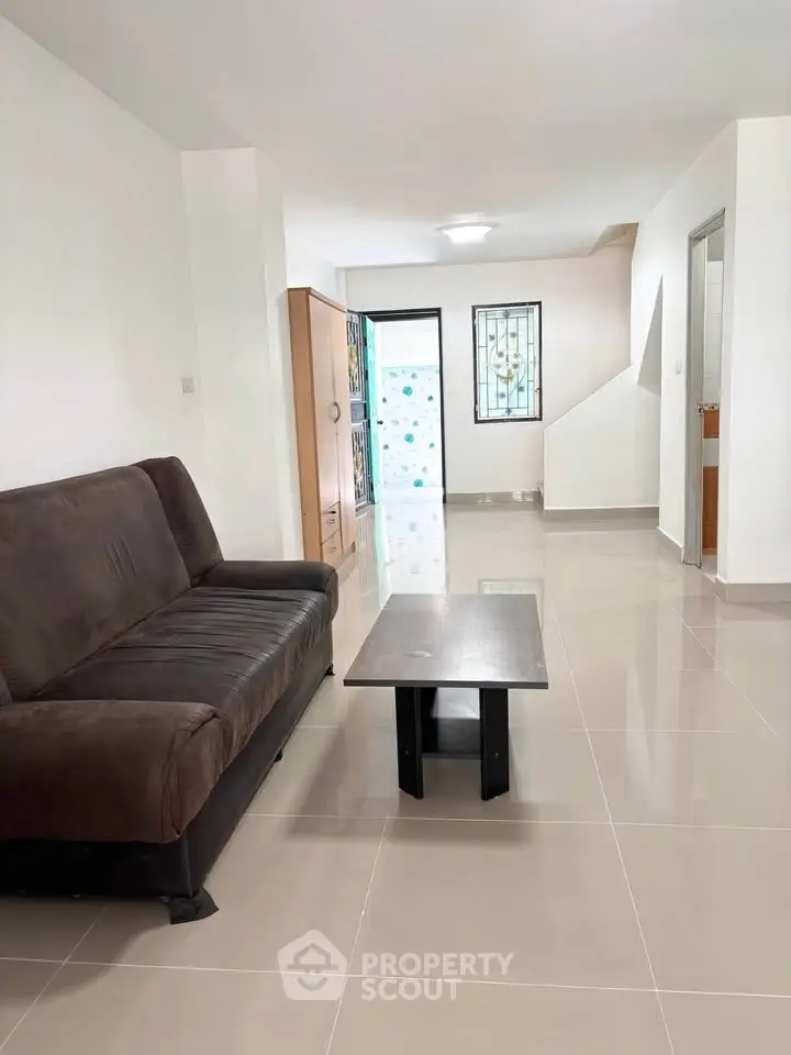 Spacious living room with modern sofa and sleek coffee table, perfect for relaxation and entertaining.