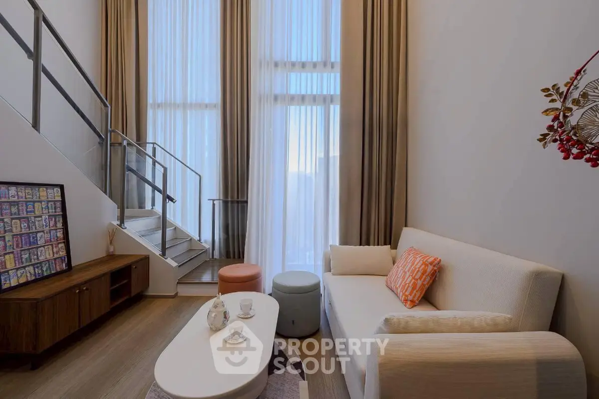 Modern living room with high ceilings and stylish decor in a contemporary apartment.