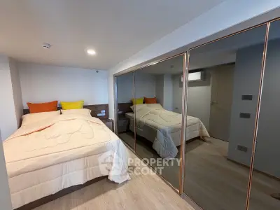 Spacious bedroom with mirrored closet and cozy bedding in modern apartment.
