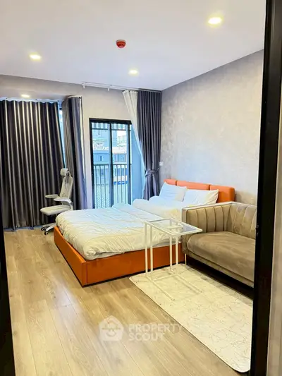 Modern bedroom with stylish decor, featuring a cozy bed, sleek sofa, and city view from the window.
