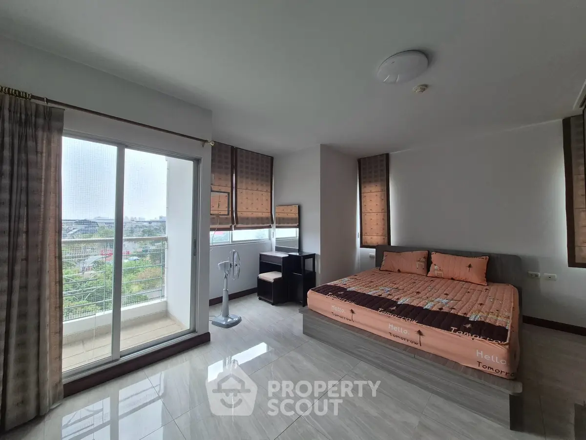 Spacious bedroom with balcony and city view in modern apartment