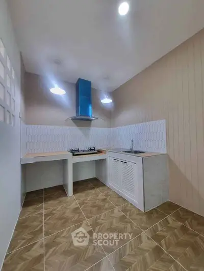 Modern kitchen with gas stove and stylish backsplash in a cozy corner layout.