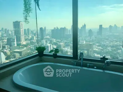 Luxurious bathroom with stunning city skyline view from large window.