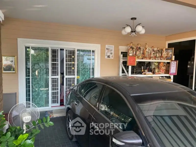 Covered carport with decorative items and sliding glass doors