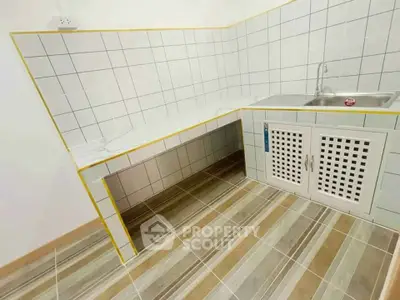 Modern kitchen with tiled countertops and striped flooring