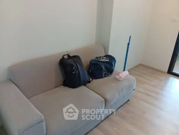 Cozy living room with modern sofa and wooden flooring, ideal for relaxation.